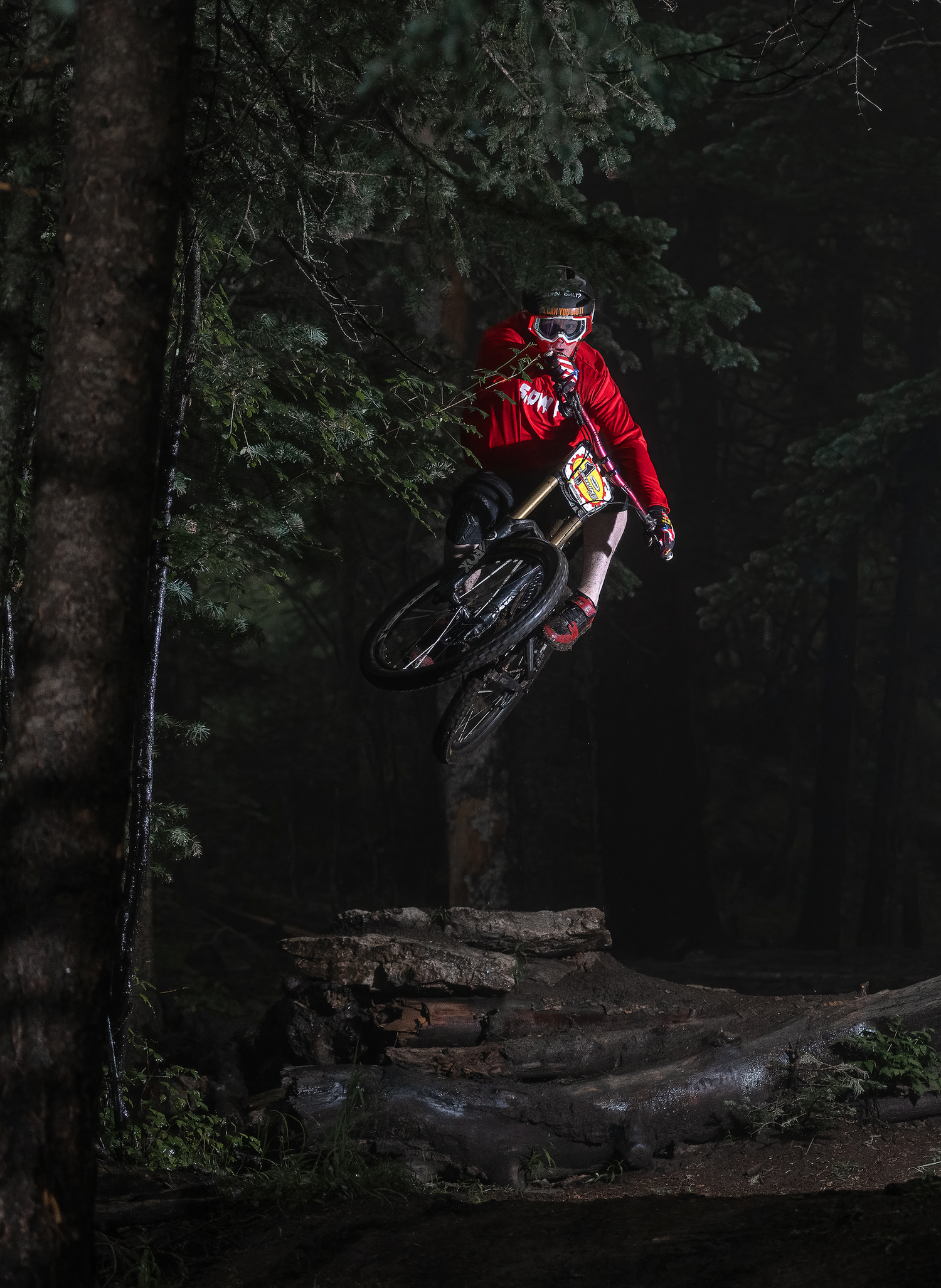 mountain bike rider jumping in the forest wearing a bicibaby slow af jersey 